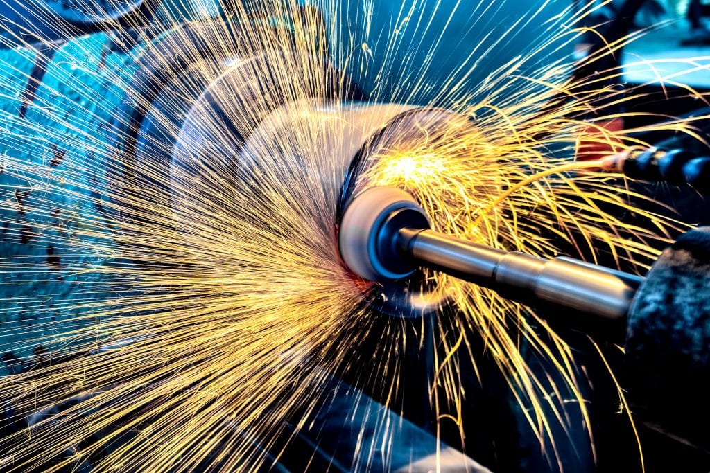 High abrasive grinder machining a cylinder and throwing sparks