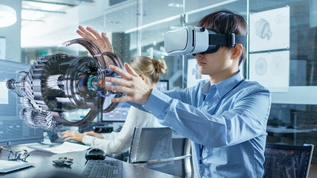 Male engineer wearing virtual reality headset and using hands to manipulate a 3D machine part model