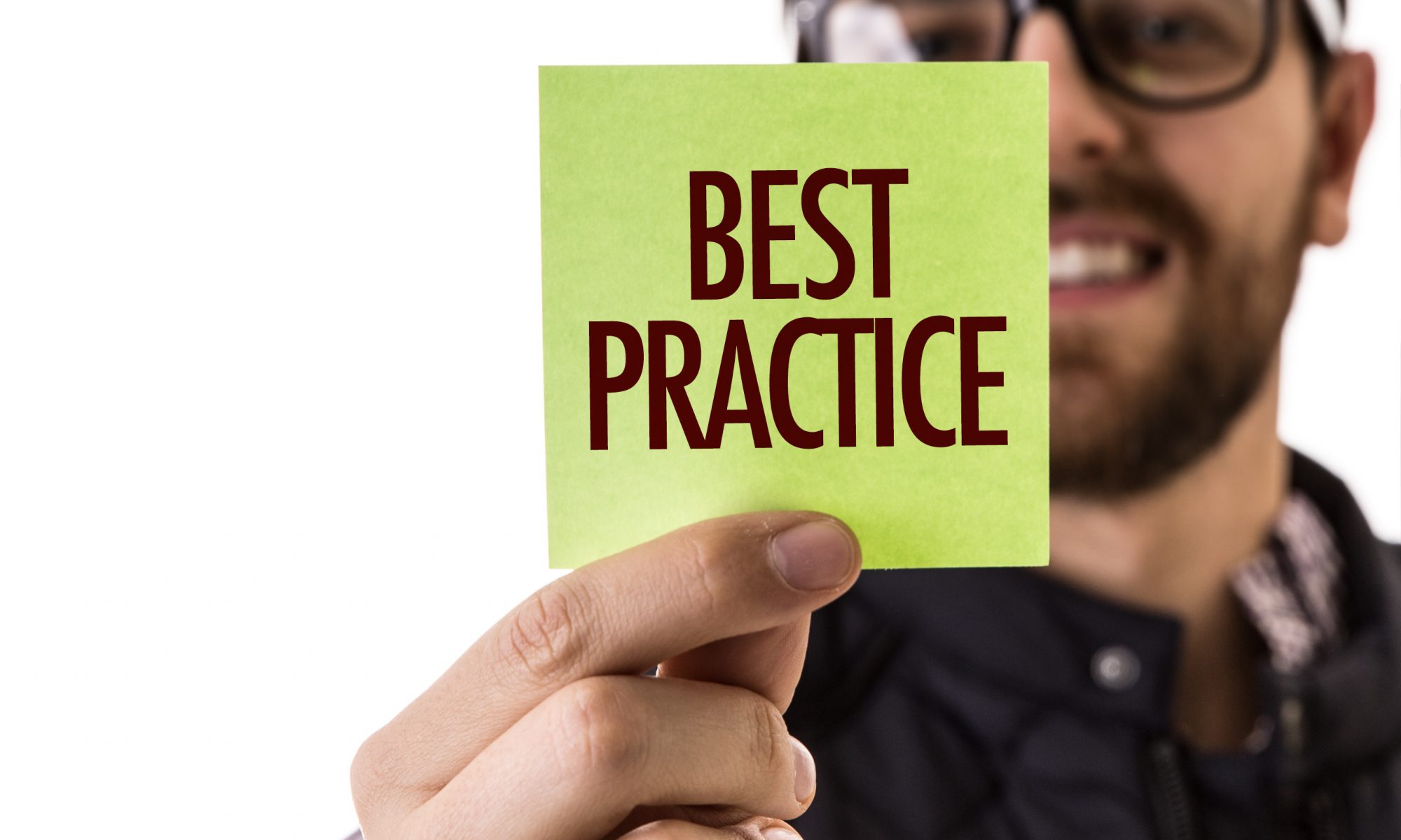 A man holding up a sticky note that says " best practice ".